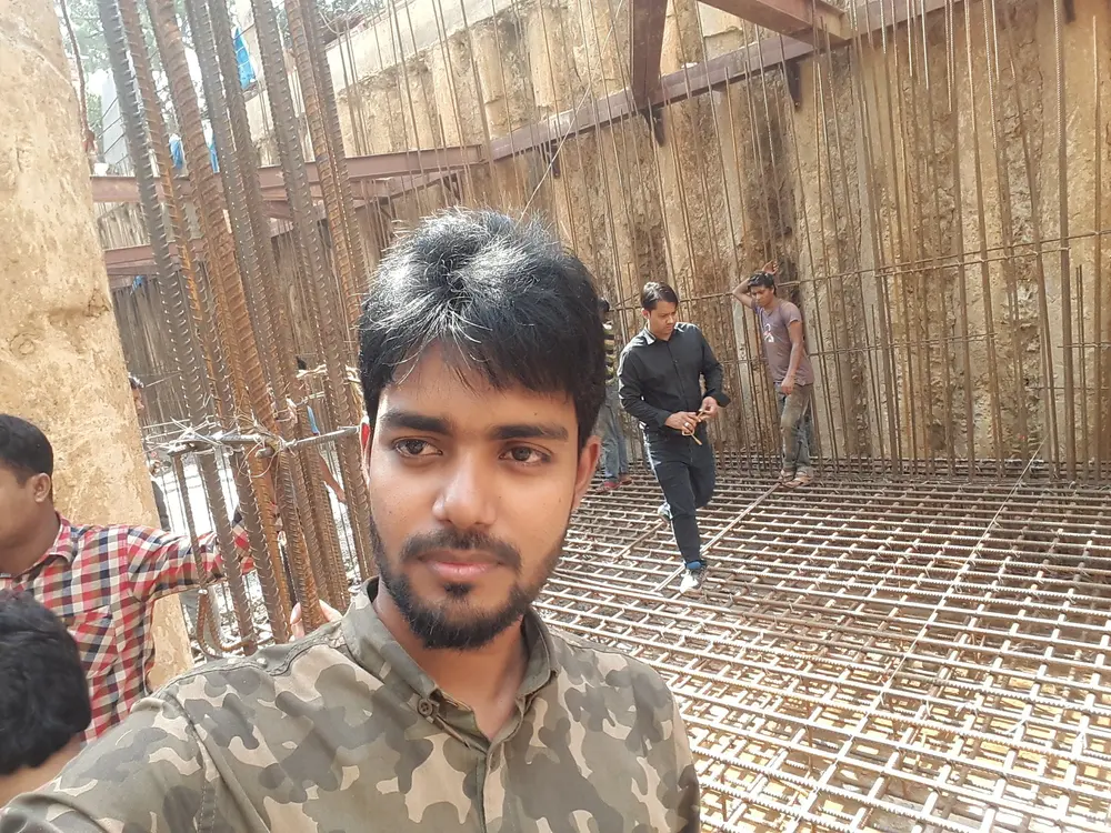 Engineer on site in a deep basement with dense vertical and mat reinforcement